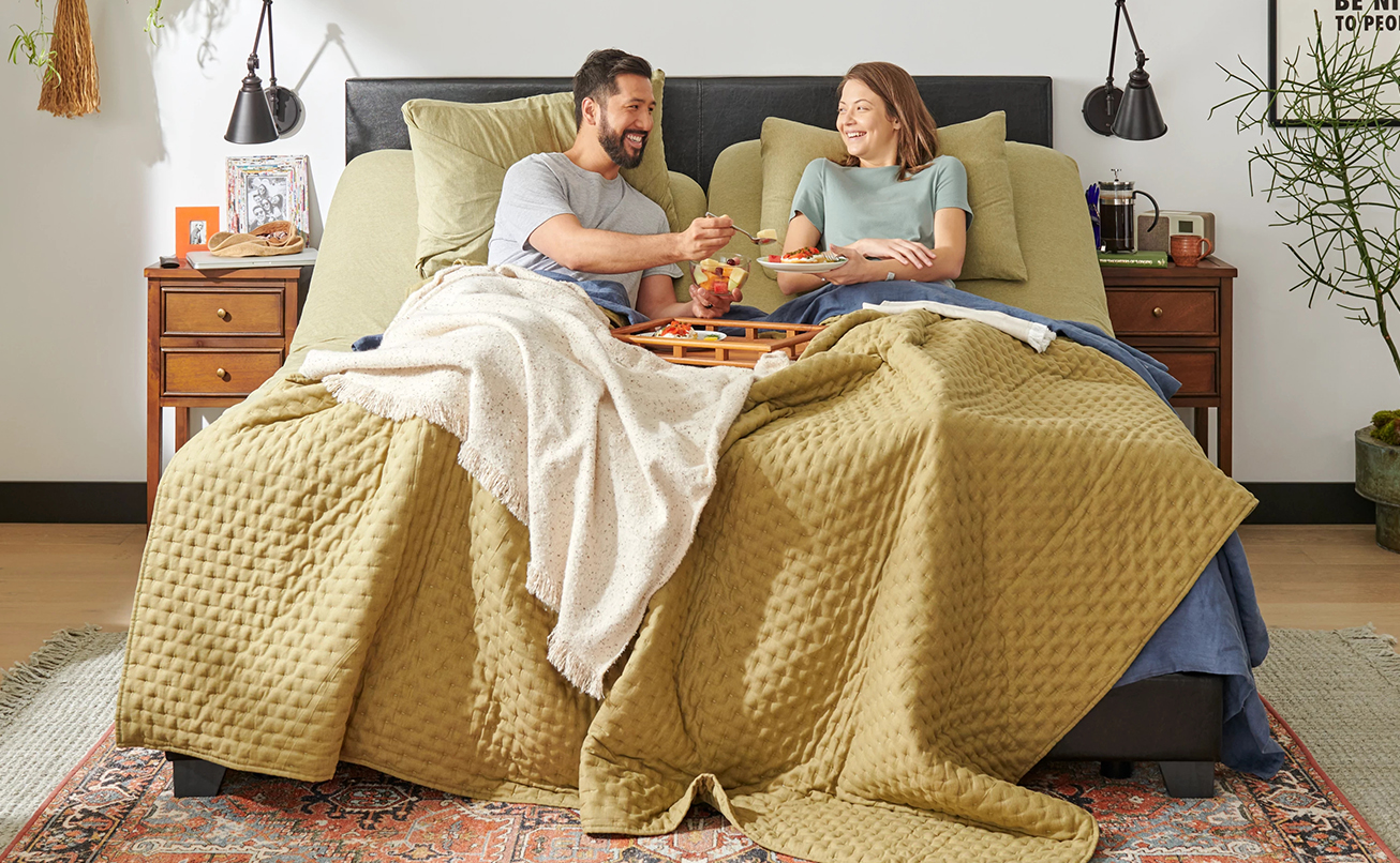 Couple laying in bed having breakfast